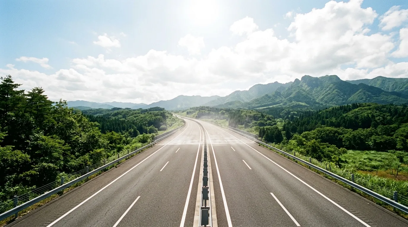真夏の日差しの下、陽炎が立つ高速道路がまっすぐ先へ続いている